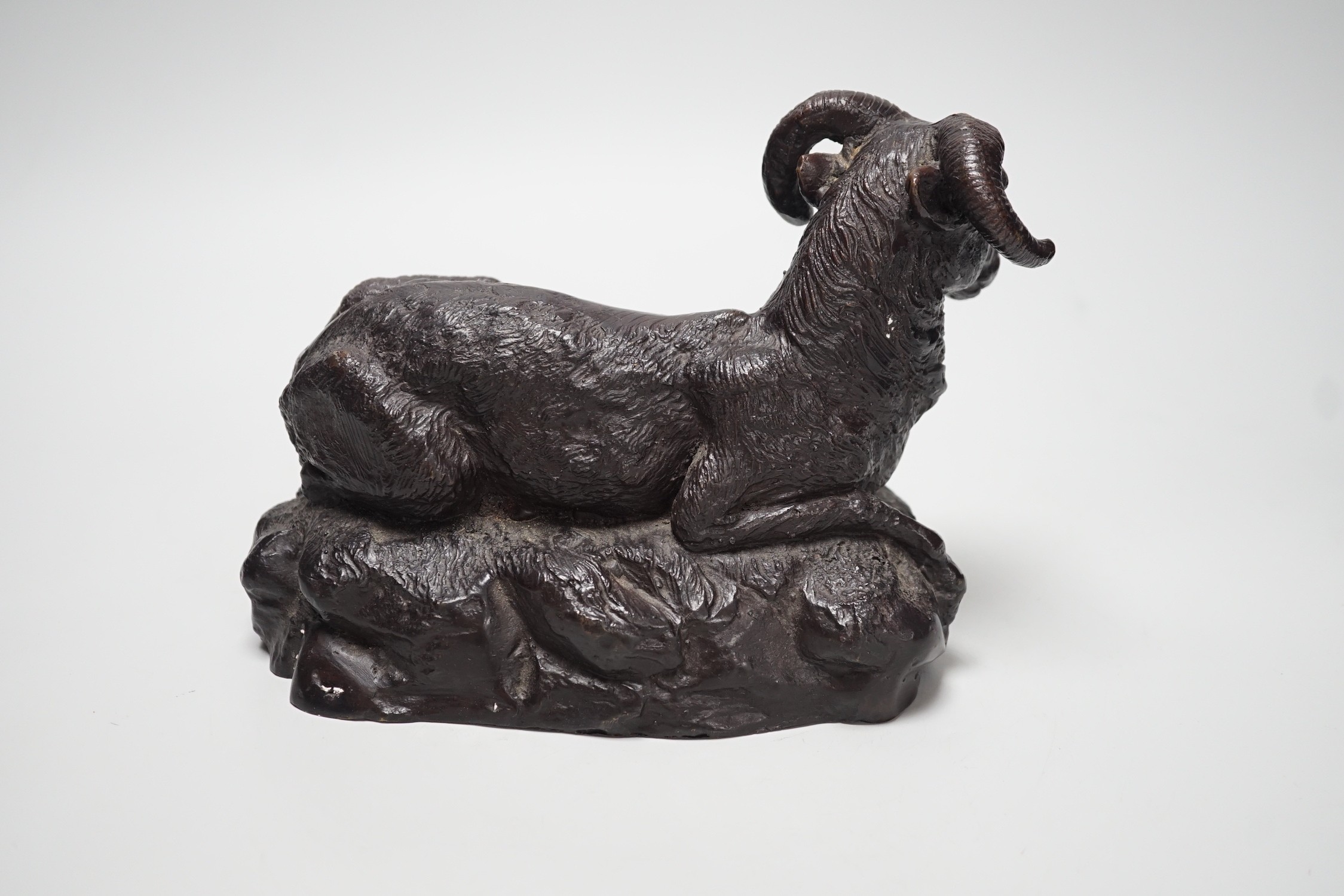 A patinated bronze of a recumbent ram, 22cm long